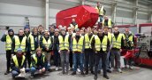 Personengruppe in Warnwesten in einer Maschinenhalle